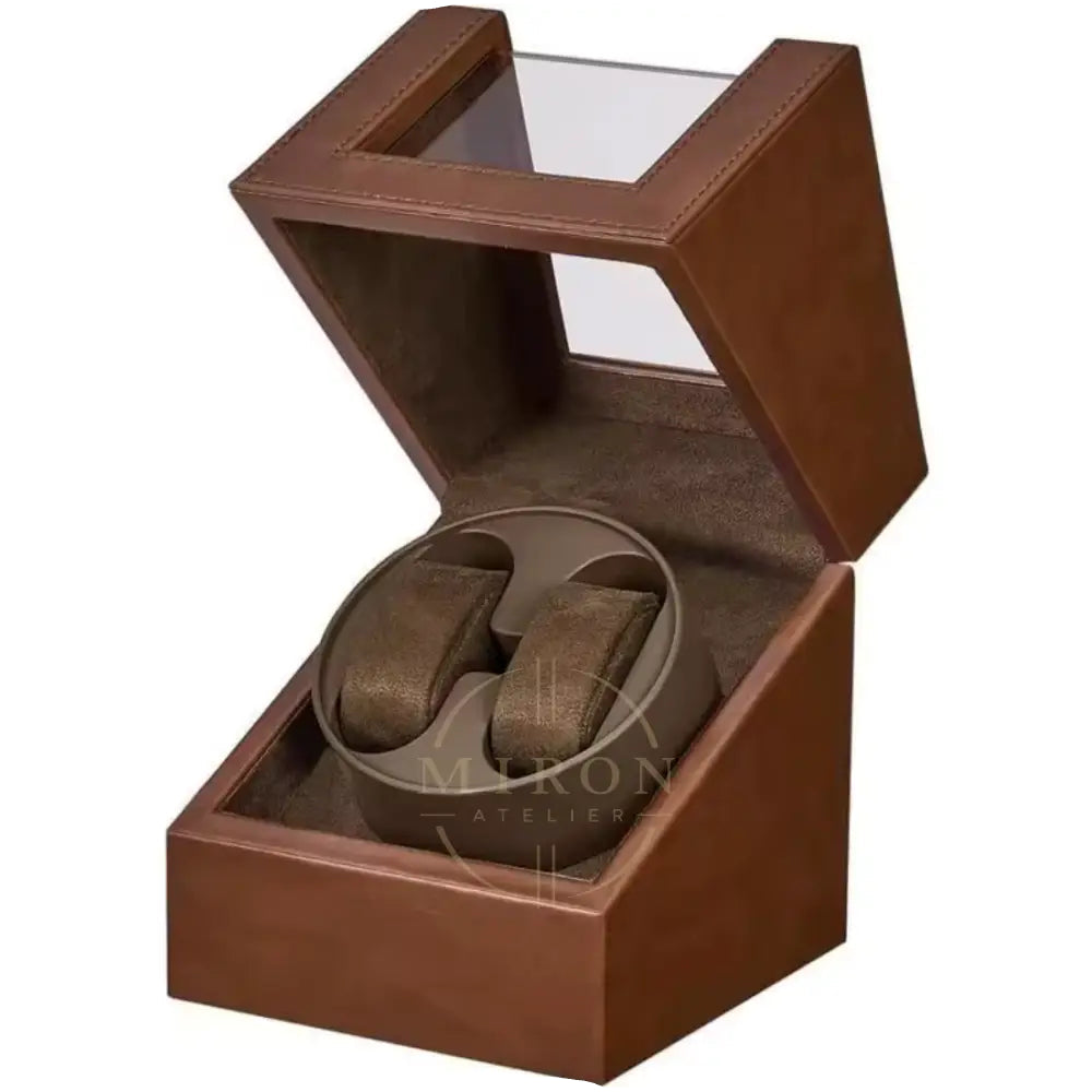 Brown watch winder box with a watch inside on a white background