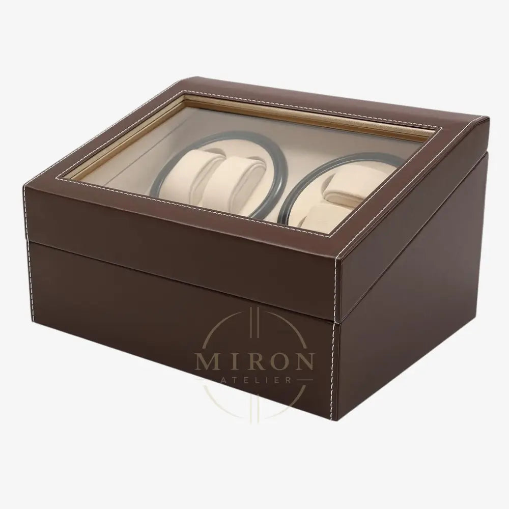 Brown leather watch box with glass top displaying two watches on a white background