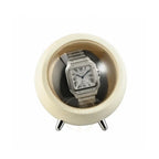 Silver Cartier watch in a round, beige auto watch winder on a white background