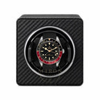 Tudor watch in a black carbon fiber watch winder on a white background