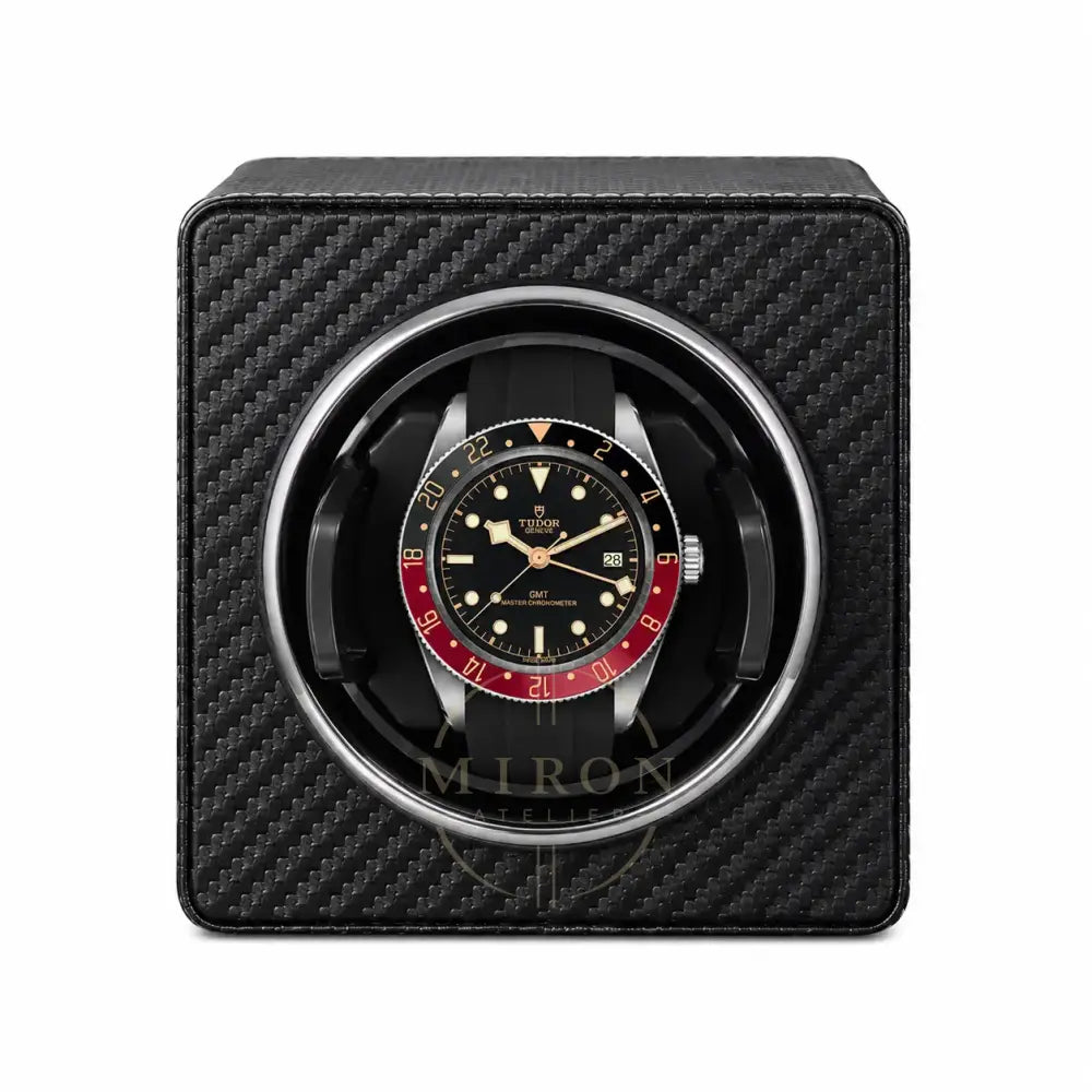 Tudor watch in a black carbon fiber watch winder on a white background