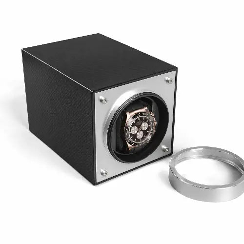 Black Rolex inside a carbon watch winder with a silver cover on a white background