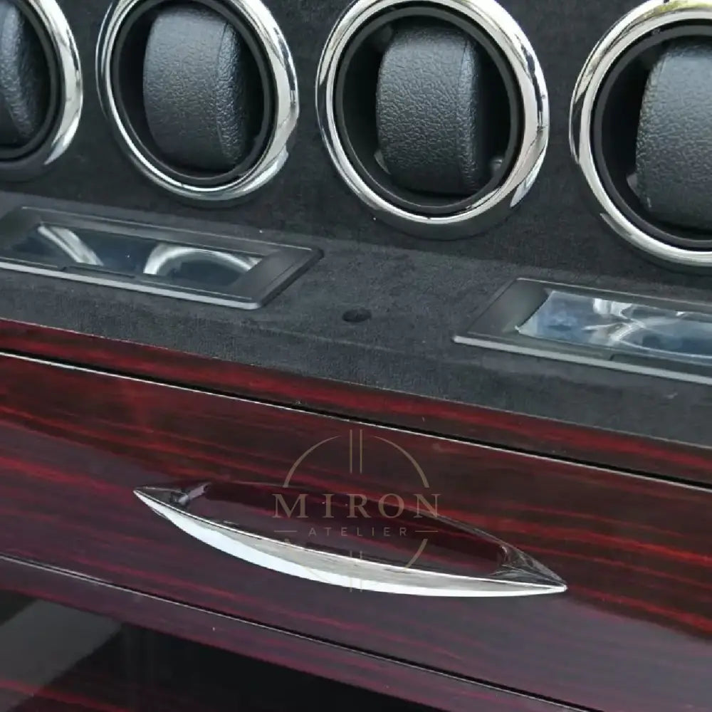Close-up of a watch winder's interior panel with drawer and rotators.