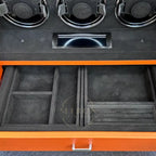 Jewelry storage compartments with black interior and orange exterior, featuring compartments and a handle.