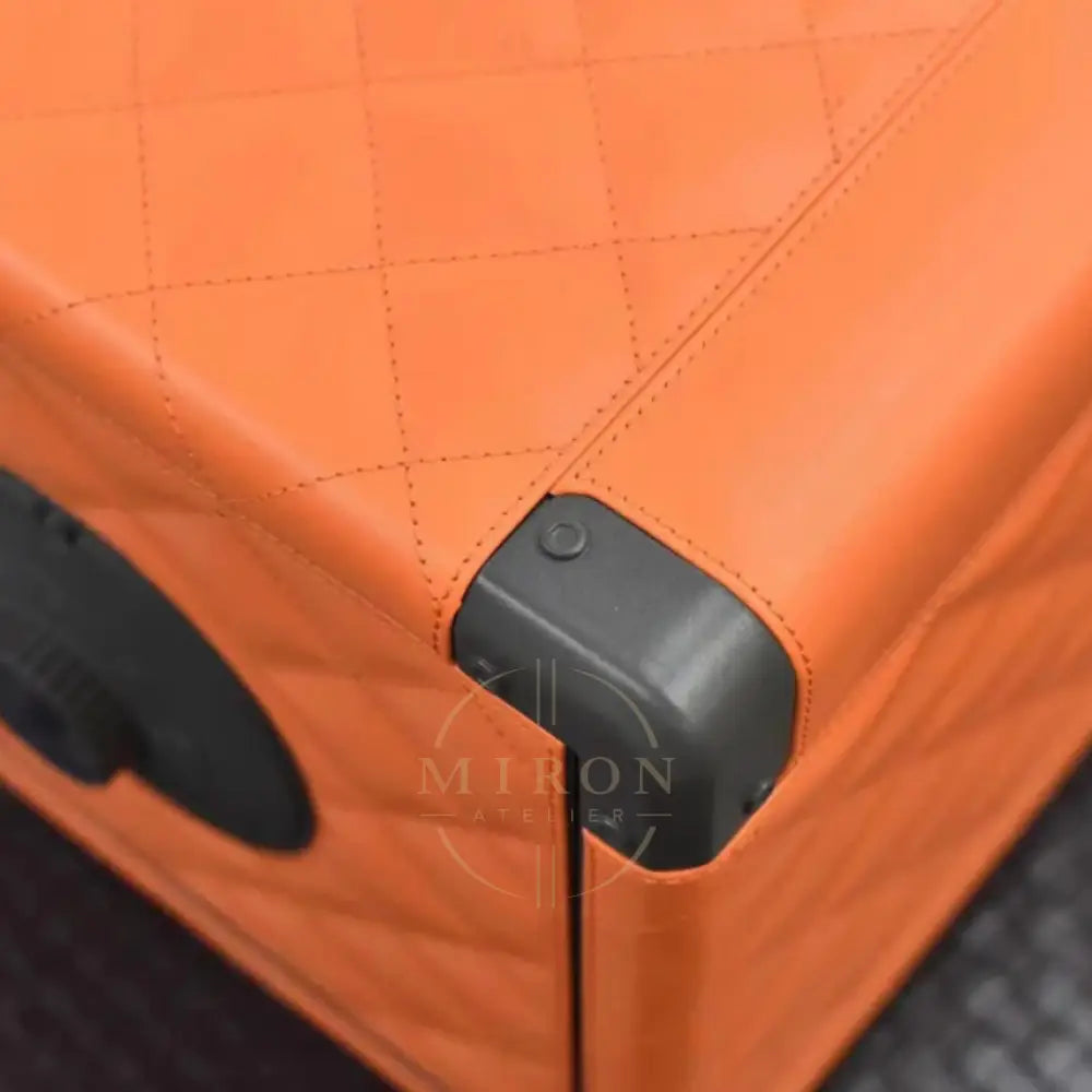 Close-up of an orange corner with a black handle and latch.