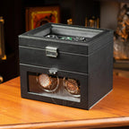 Black watch box with two watches on a wooden surface