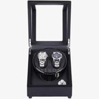 Black watch winder with two watches inside on a white background