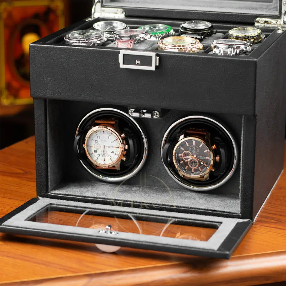 Black watch winder box with two rotating watch cases on a wooden surface