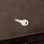Silver key-shaped bottle opener on a brown leather surface