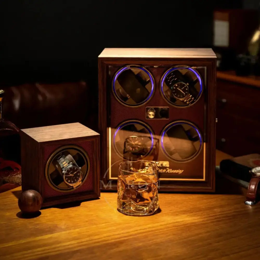 Wooden watch winder with two watches and a glass of whiskey on a wooden table.