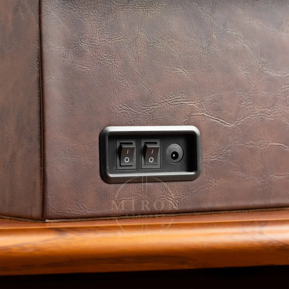 Control panel with switches on a brown leather surface