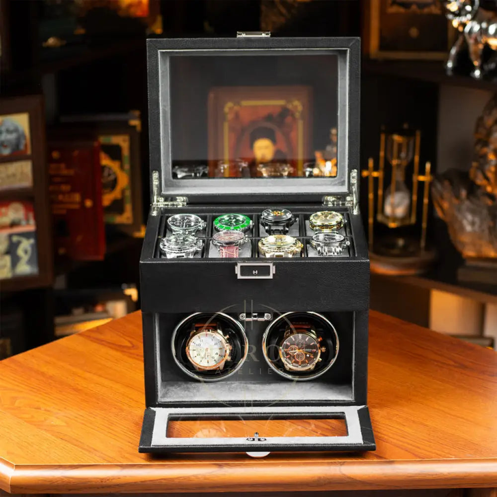 Black watch winder with two rotating compartments on a wooden surface.