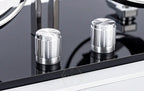 Close-up of metallic knobs on a reflective surface of an automatic watch winder