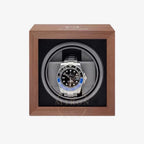 Rolex watch in a wooden watch winder with a white background