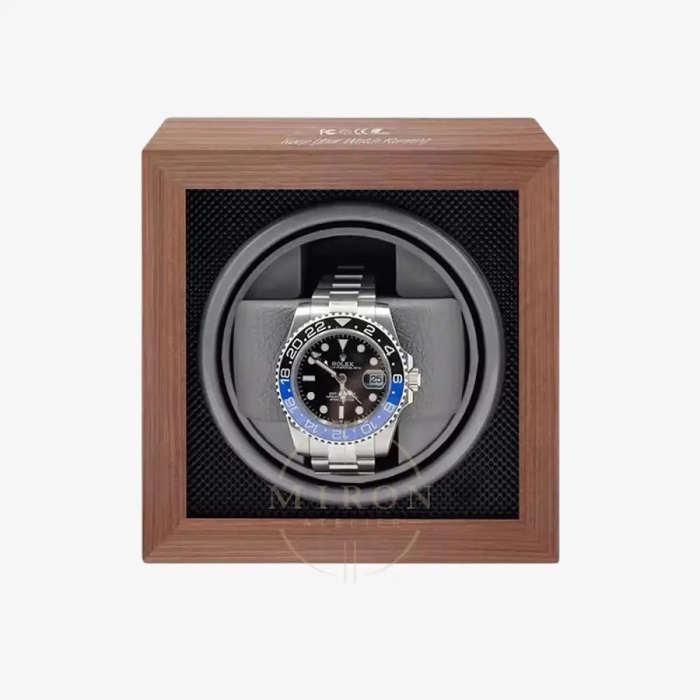Rolex watch in a wooden watch winder with a white background