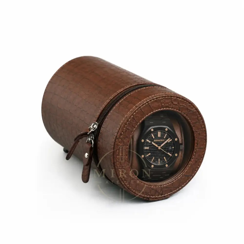 Brown crocodile-rounded watch winder with a black Audemars luxury watch inside