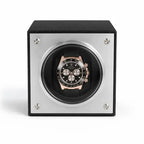 Watch winder with a black and rose gold Rolex Daytona watch inside on a white background
