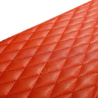 Close-up of a orange quilted leather surface
