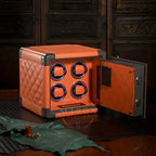 Orange watch winder with open door on a wooden surface