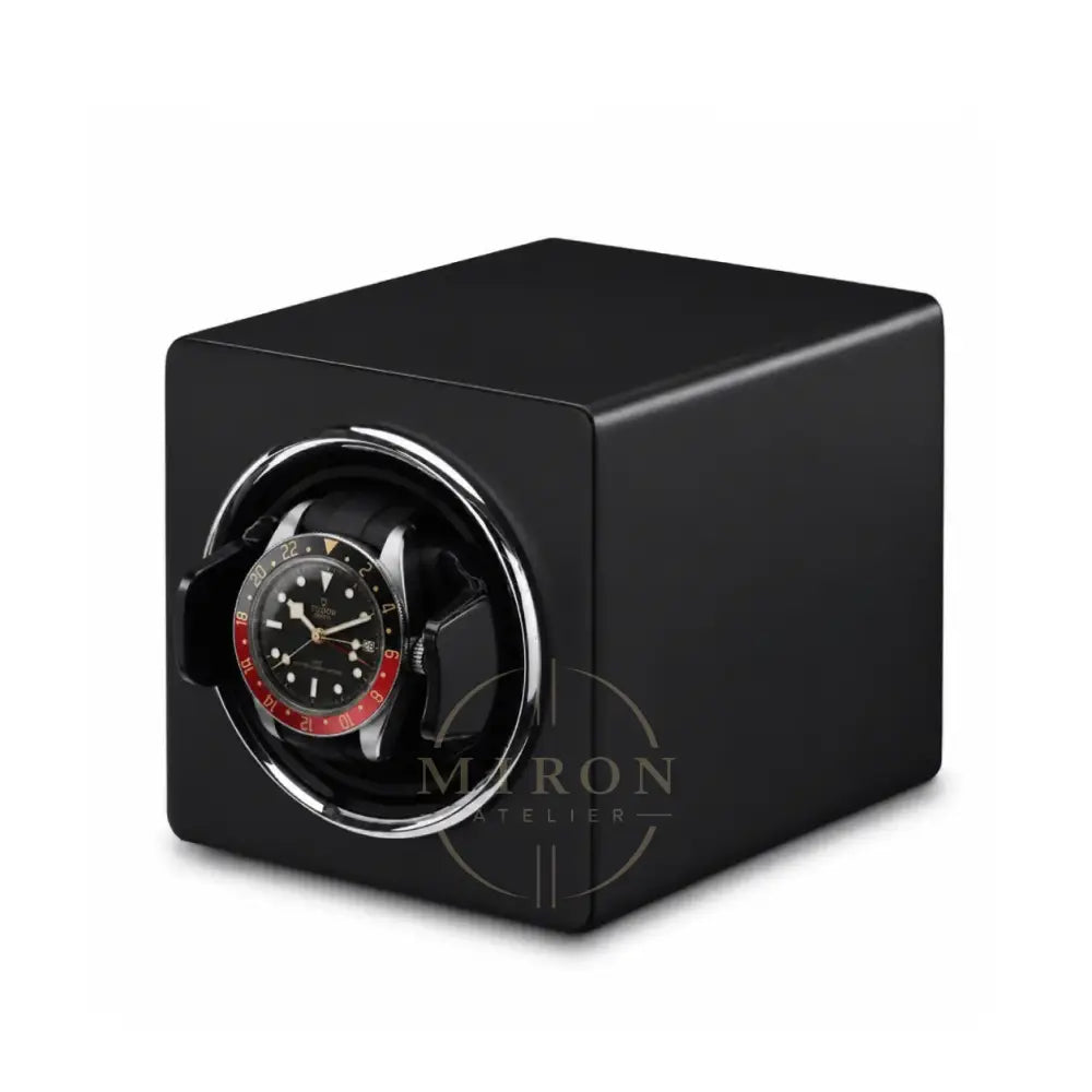 Black matte watch winder with a Tudor watch inside on a white background