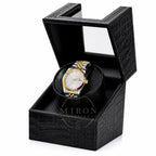 Gold and silver Seiko watch in a black crocodile watch winder patterned box on a white background