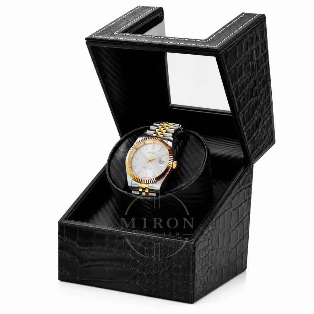 Gold and silver Seiko watch in a black crocodile watch winder patterned box on a white background