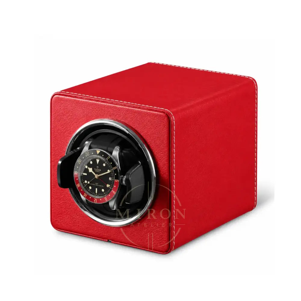 Red leather watch winder with a black Tudor watch inside on a white background