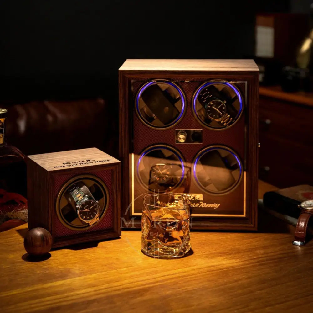 Wooden watch winder with two rolex watches and a glass of whiskey on a wooden surface.