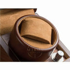 Close-up of a brown leather watch winder in a white background