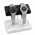 Two silver luxury watches Tudor and Audemars Piguet on a marble watch stand with a white background