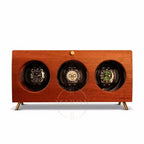 Wooden watch winder with three watches on a white background
